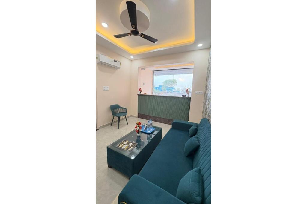 a living room with a blue couch and a projection screen at Hotel Raas Grand in Sachendi