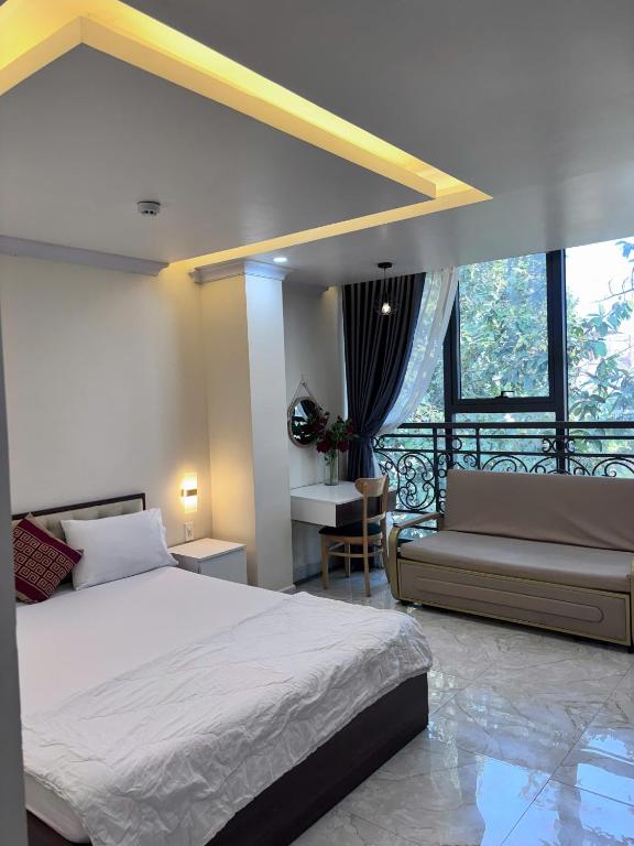 a bedroom with a bed and a couch at Sao Việt Nam Hotel in Ho Chi Minh City