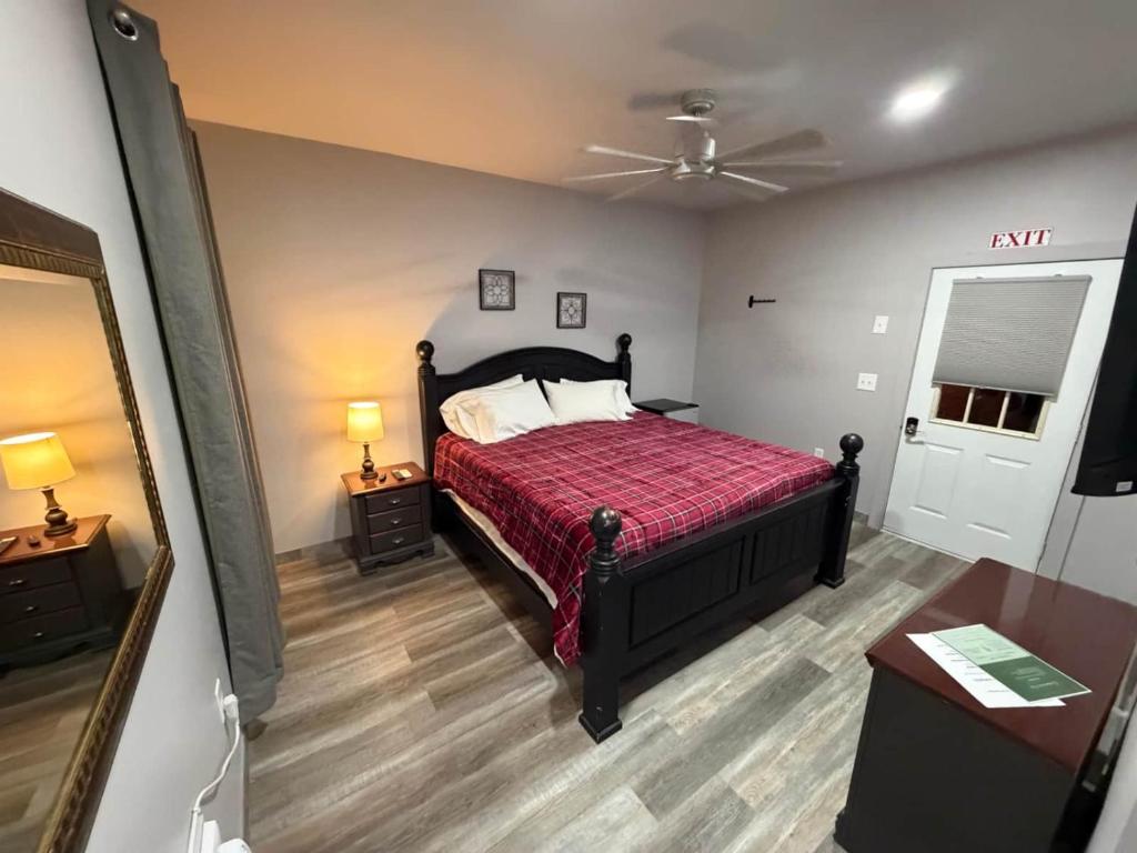 a bedroom with a bed with a red comforter at Germantown Inn & Lounge in Hermann