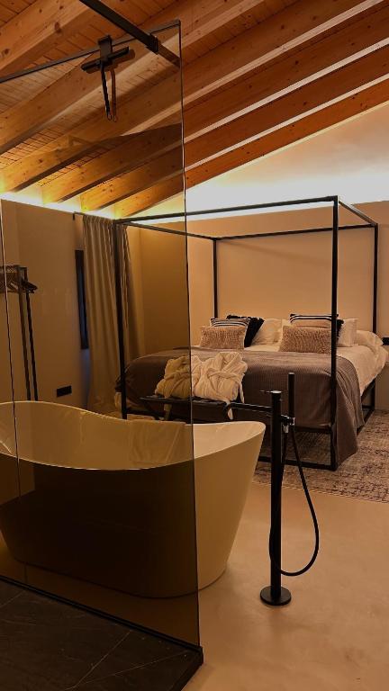 a bath tub in a room with a bed at Enoa Casa Cueva - Alojamiento rural in Requena