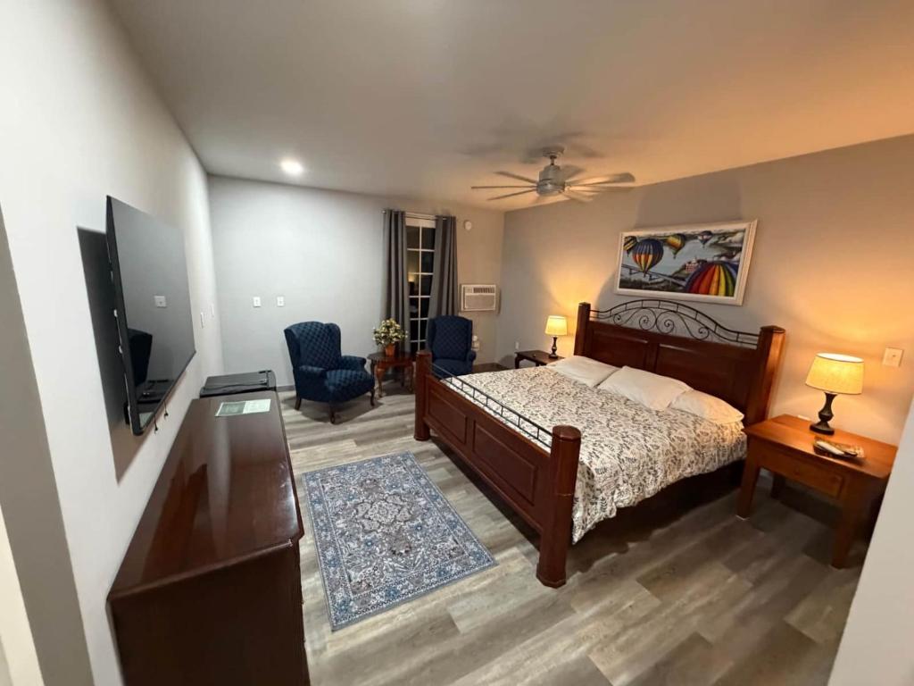 a bedroom with a bed and a flat screen tv at Germantown Inn & Lounge in Hermann
