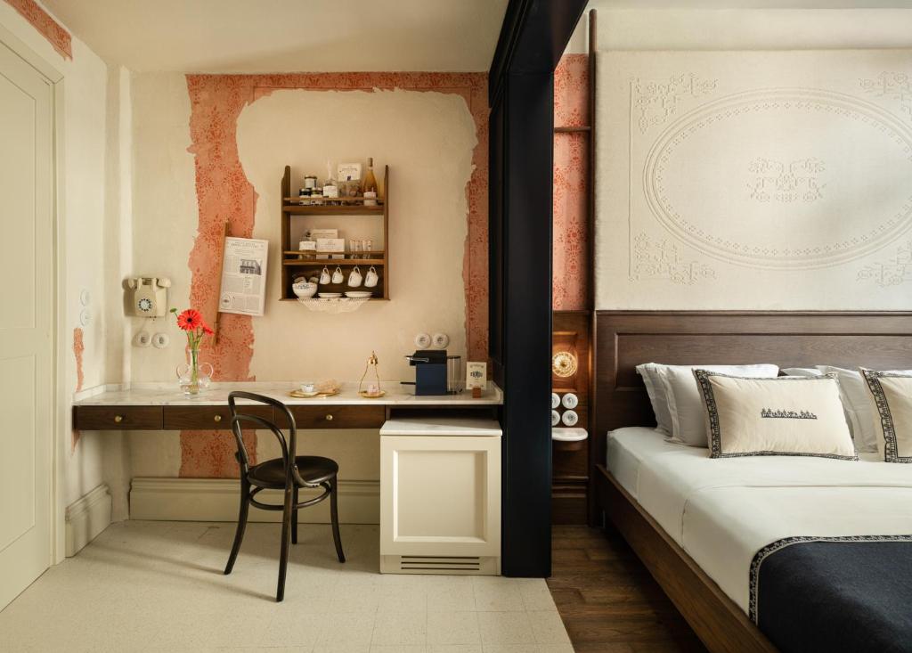 a bedroom with a bed and a desk with a chair at Ergon House Ermou in Athens