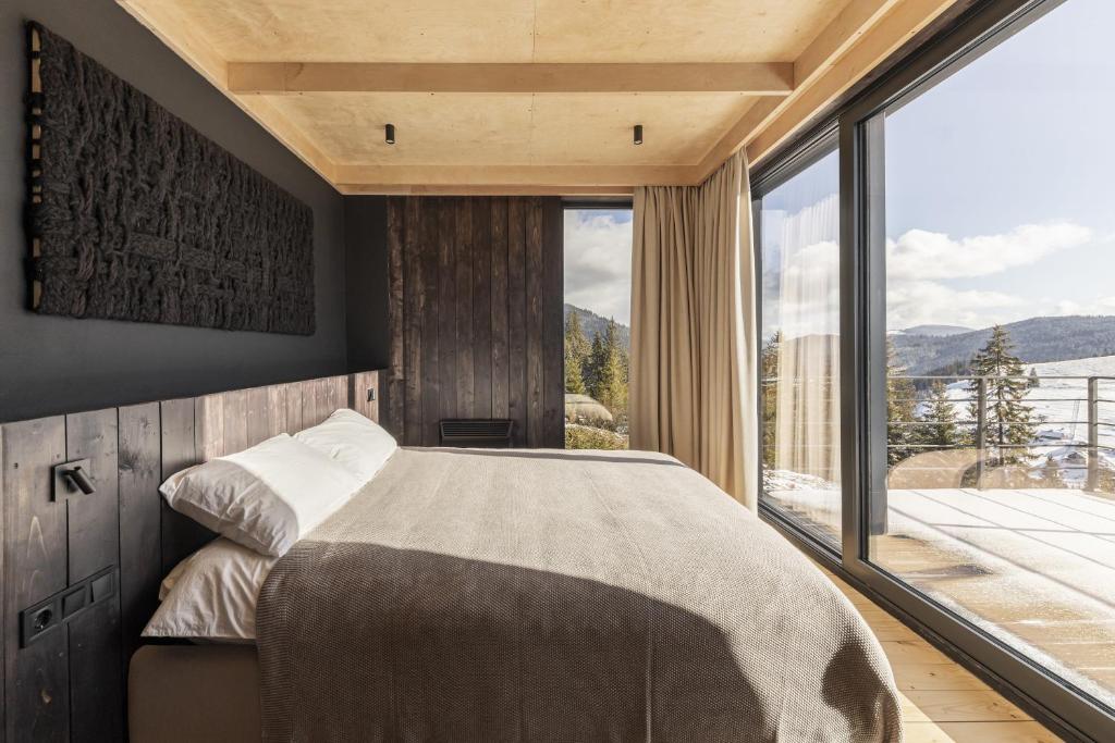 a bedroom with a large bed and a large window at Mountain air Horishnii in Palyanytsya
