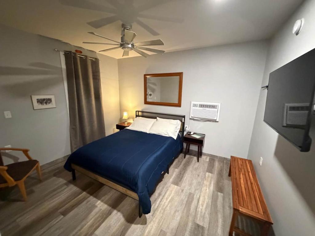 a bedroom with a blue bed and a ceiling fan at Germantown Inn & Lounge in Hermann