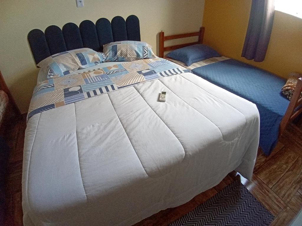a bedroom with a large bed with a blue headboard at Pousada São Benedito CP in Cachoeira Paulista