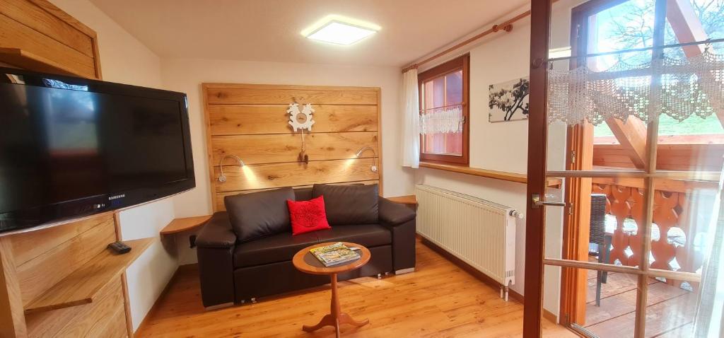 a living room with a couch and a flat screen tv at Gästehaus Holzer Kreuz - Ferienwohnung "Mohn" in Fröhnd