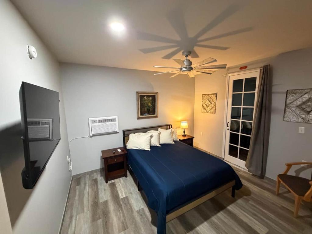 a bedroom with a blue bed and a ceiling fan at Germantown Inn & Lounge in Hermann