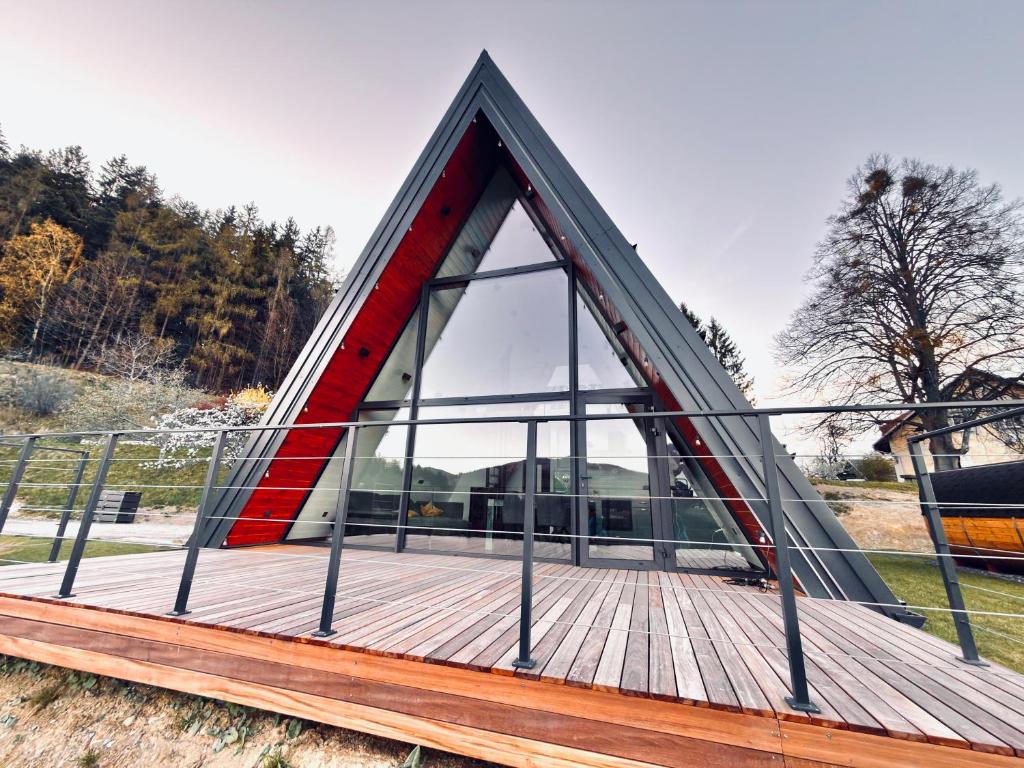 a house with a triangular roof on a wooden deck at Villa Perush in Vuzenica