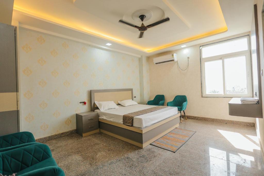 a bedroom with a bed and chairs and a ceiling at Regal Palace Hotel and Banquets in Patna