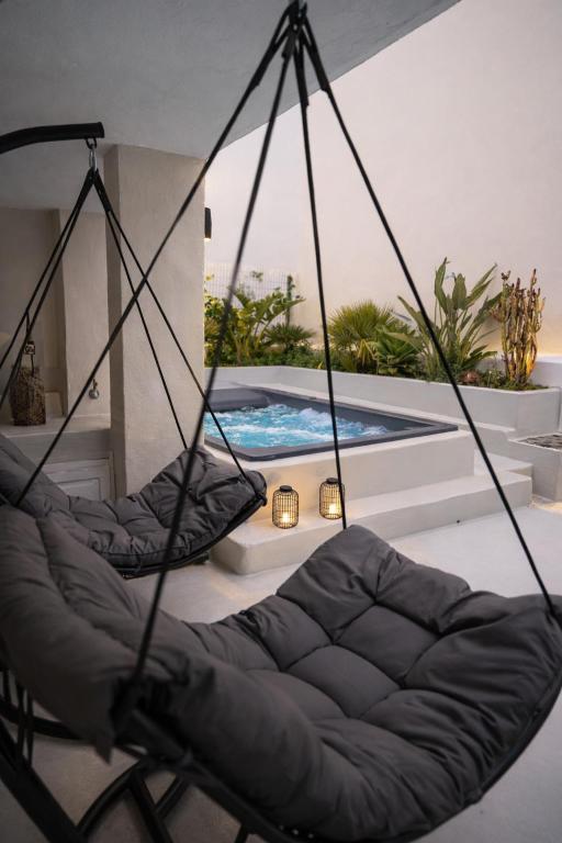 a swing chair in front of a swimming pool at Rosaviglia Luxury Villa - an Oia Private Hideaway in Oia