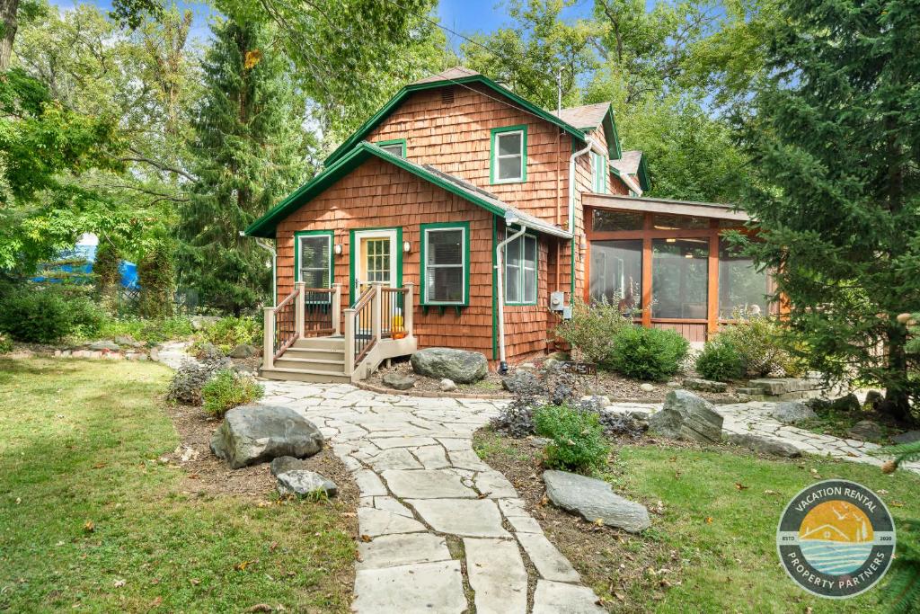 a small wooden house with a stone path in front of it at Lake Geneva Escape 4BR Arcade Fire Pit and Deck in Lake Geneva