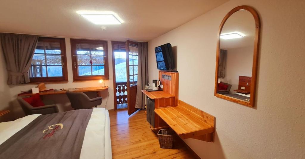 a hotel room with a bed and a mirror at Gästehaus Holzer Kreuz - Gästezimmer Veilchen für 2 Personen inkl Landfrühstück in Fröhnd