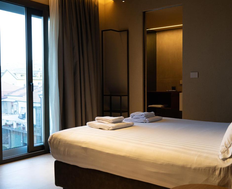 a hotel room with a bed with towels on it at Ku Private Milano in Pero