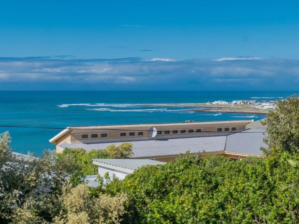 a large building with the ocean in the background at Ocean View 147 in Struisbaai