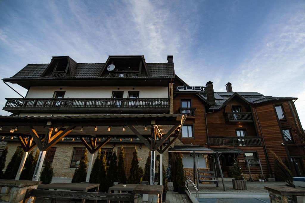 a large wooden building with a balcony at Гук готельно-ресторанний комплекс in Bukovel