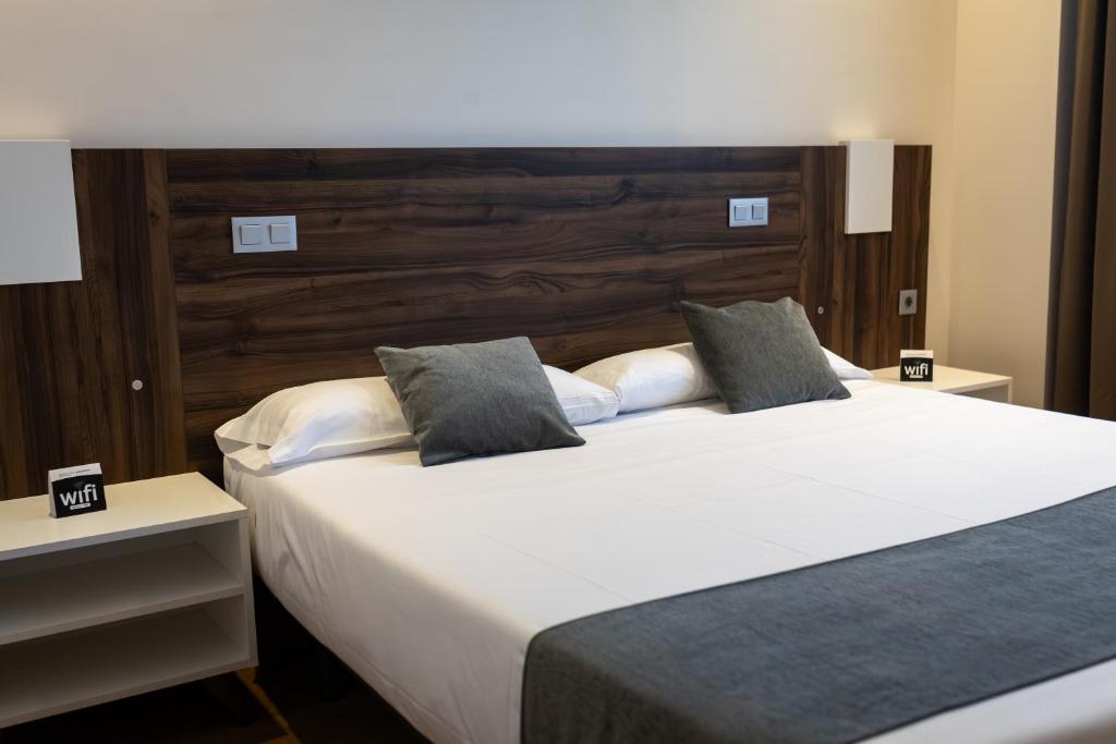 a bedroom with a large bed with white sheets and pillows at Alda Ruta Castilla in Palencia