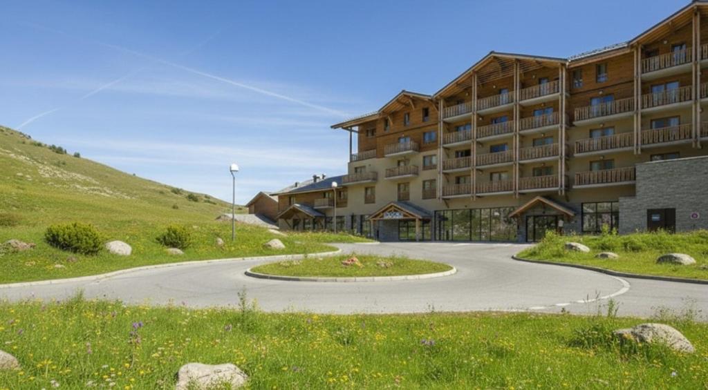 a winding road in front of a large building at SOWELL HÔTEL L'Alpe Blanche in Vars