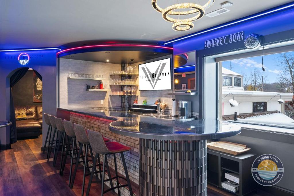 a bar in a restaurant with stools around it at Event Lounge with Pool Table and Arcade in Lake Geneva