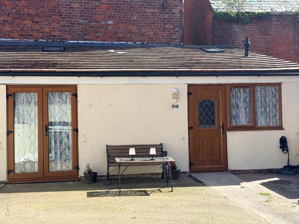 a bench in front of a building with a door at Casa G in Bridlington