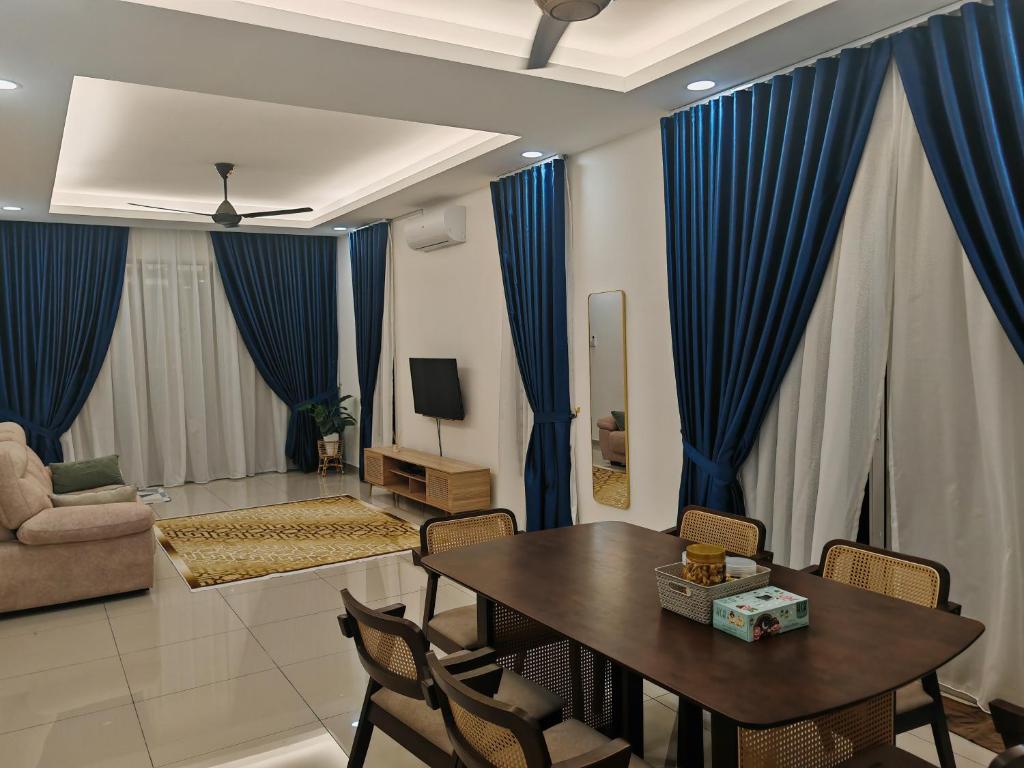 a living room with blue curtains and a table and chairs at Homestay Amna DShorea in Port Dickson