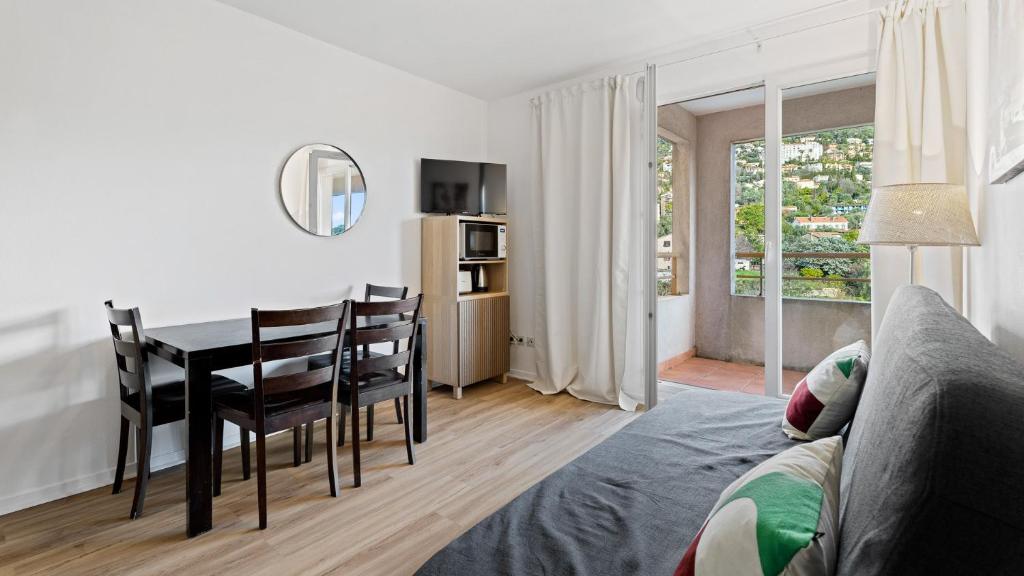 a living room with a table and chairs and a dining room at Virginia N302 - 2p4 in Grasse