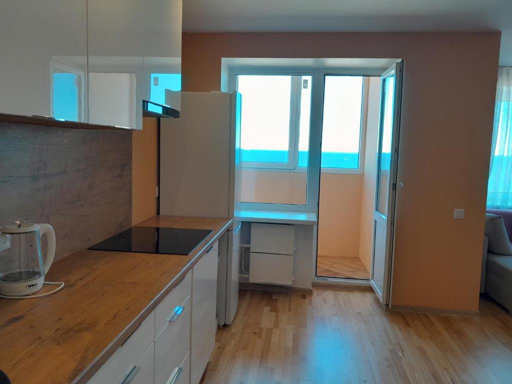 a kitchen with a refrigerator and a door to a room at VP Apartment Sillamäe in Sillamäe