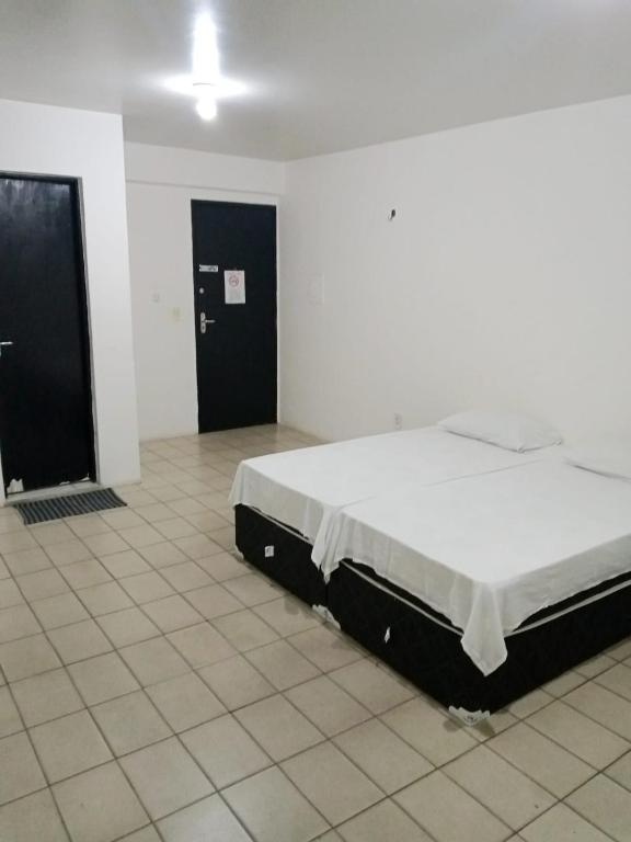 a bedroom with a bed in the middle of a room at Pousada Amarela in Fortaleza
