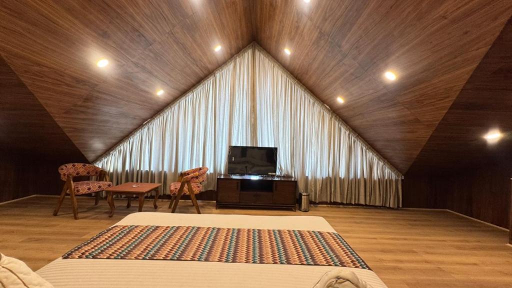 a large room with a bed and a tv in it at Emroz Kings Resort in Batakūt