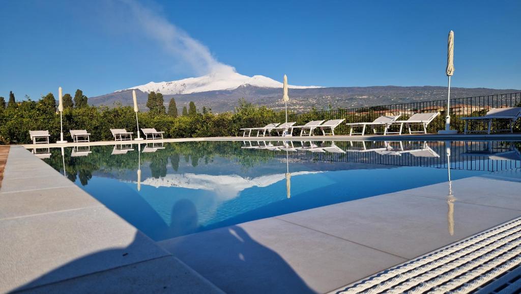 a swimming pool with a mountain in the background at Lumia in Riposto