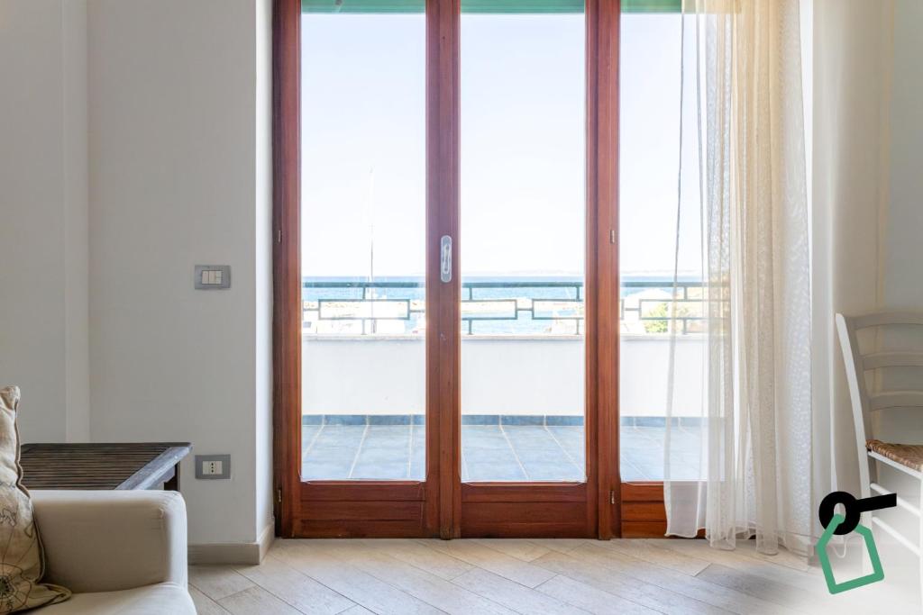 a room with sliding glass doors with a view of the ocean at Hotiday Gallipoli Lungomare in Gallipoli