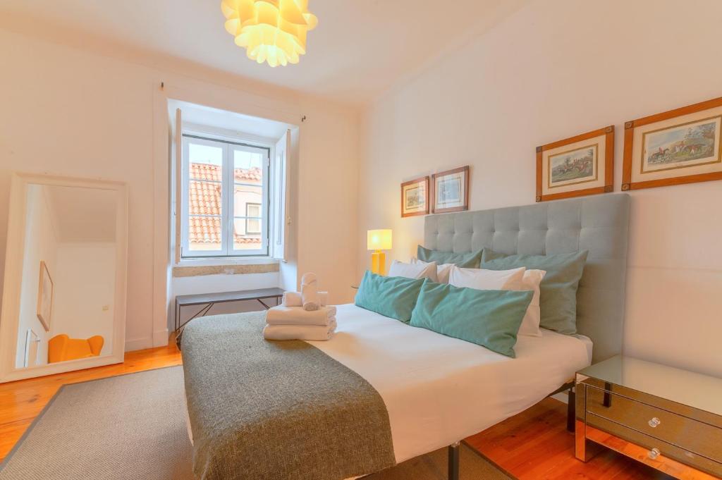 a bedroom with a large bed and a window at Portas da Sé Apartments in Lisbon
