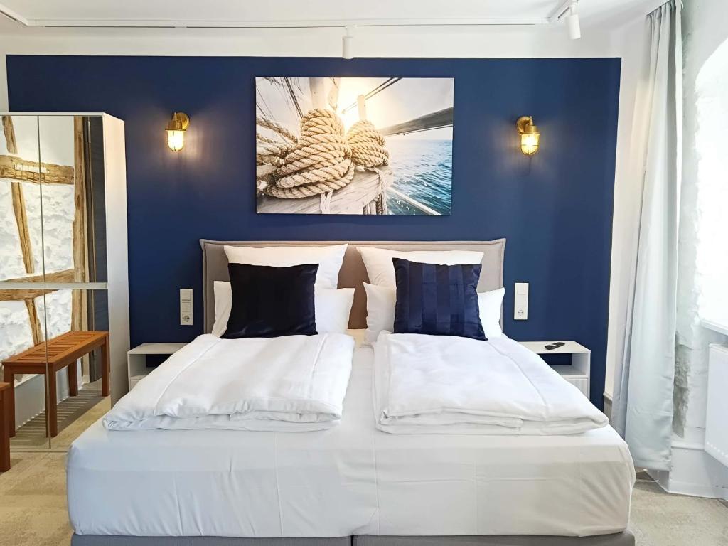 a bedroom with a white bed with blue walls at NOX HOTEL - Digital-Check-In - No Reception - nahe Bretten & Karlsruhe - 2 Nautic in Wössingen