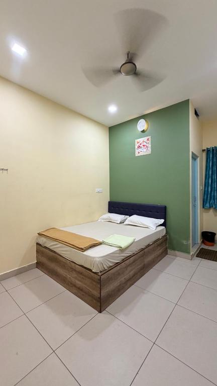 a bed in a room with a green wall at Gravity Groups VHR Residency - near santho lawns in Pondicherry