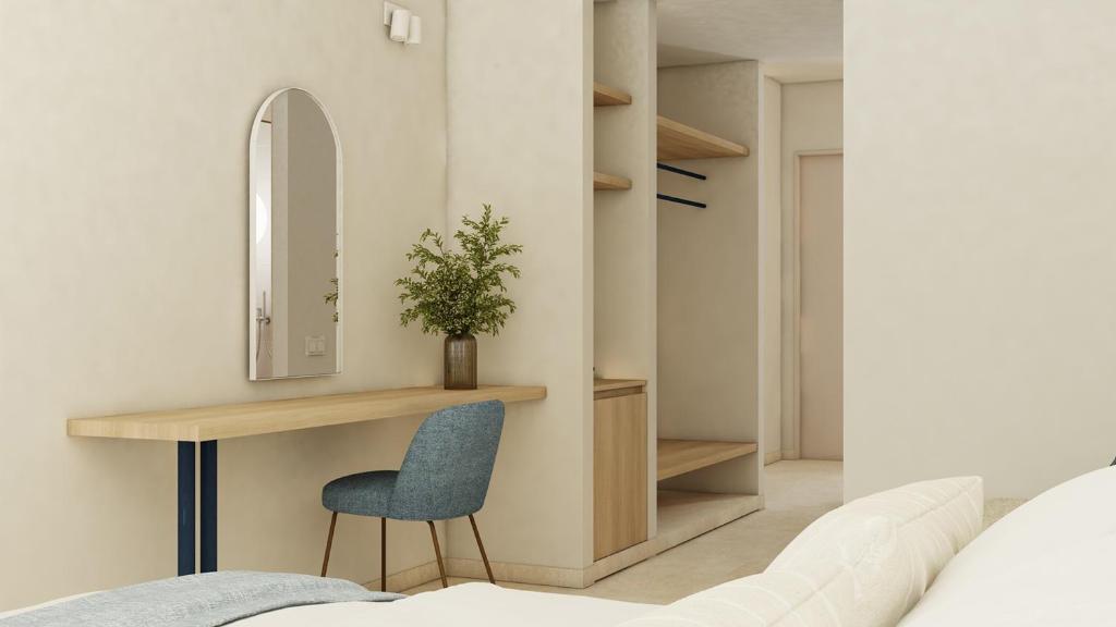 ein Schlafzimmer mit einem Schreibtisch und einem blauen Stuhl in der Unterkunft Captains De Luxe in Argassi
