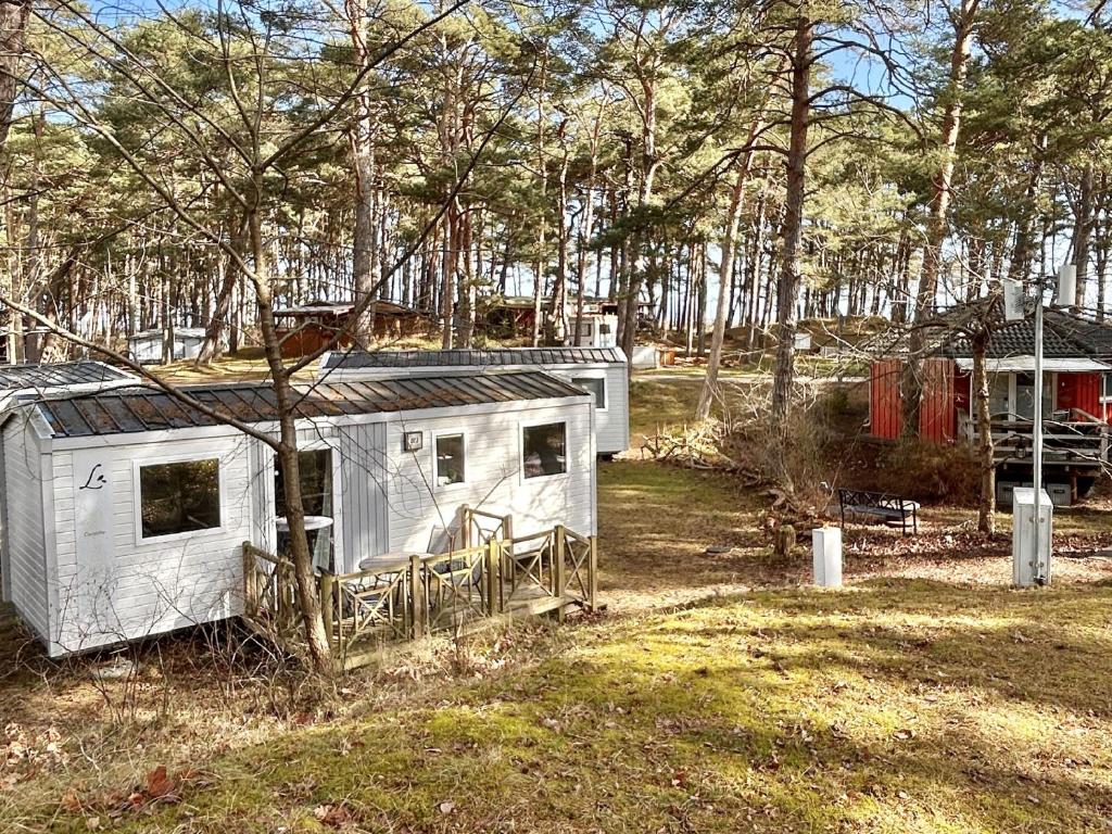 a small white trailer in a field with trees at Tiny Home Strandkoje 823 in Göhren
