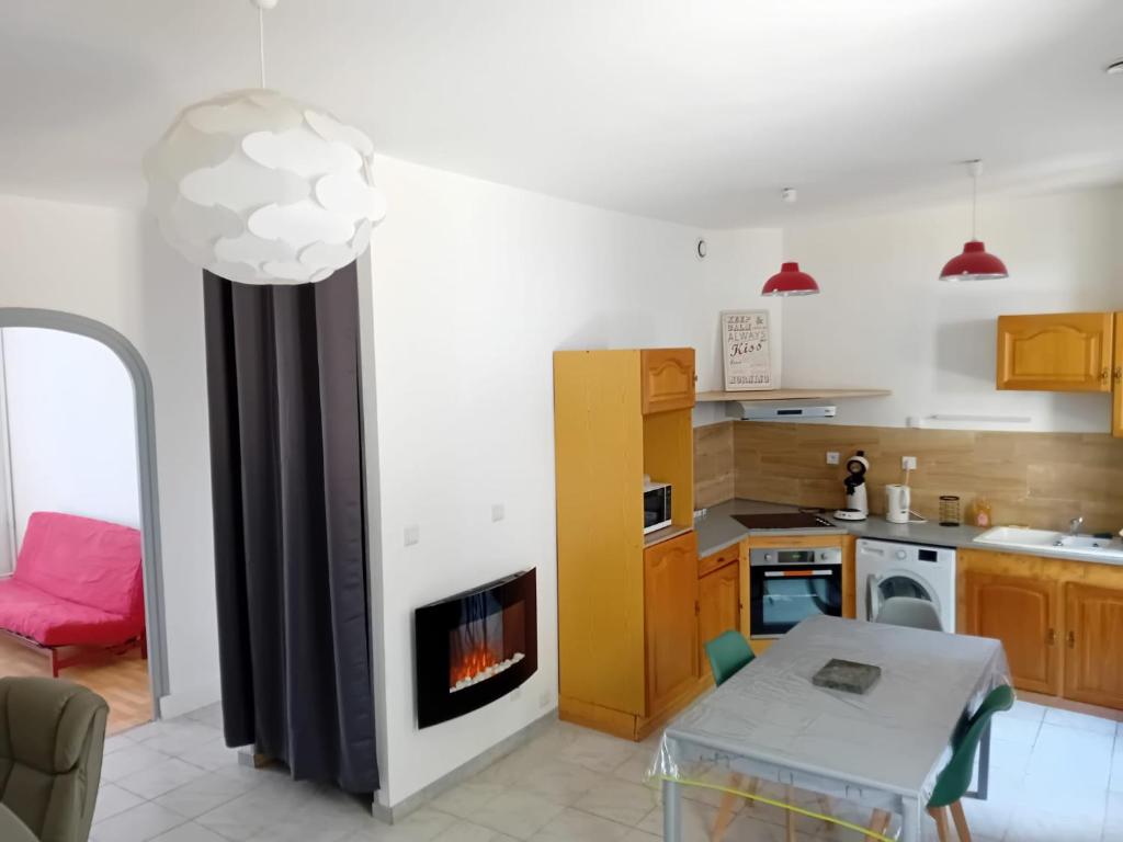 a kitchen with a living room with a fireplace at Appartement avec terrasse 53m2 in Saint-Martin-de-Valamas