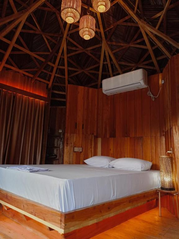 a bedroom with a large bed with a wooden ceiling at Bonomali Mangrove Resort in Dhāngmāri Forest Office