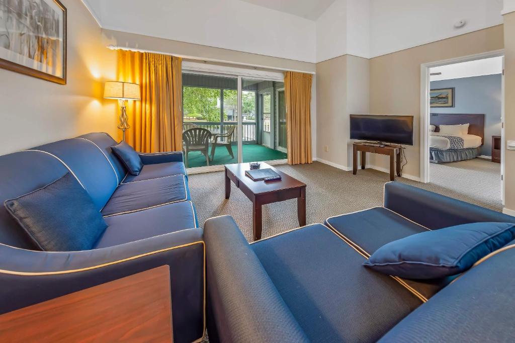 a living room with two blue couches and a television at 2 Bedroom Condo on Lake with Jacuzzi in New Bern