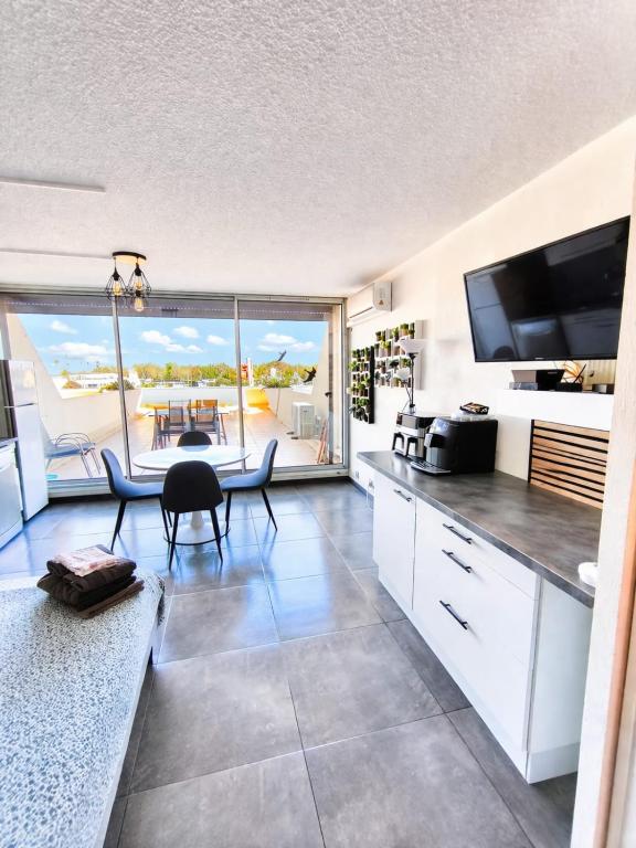 a kitchen with a dining table and a view of the ocean at Naturiste Cap d'Agde Héliopolis K 106 in Cap d'Agde