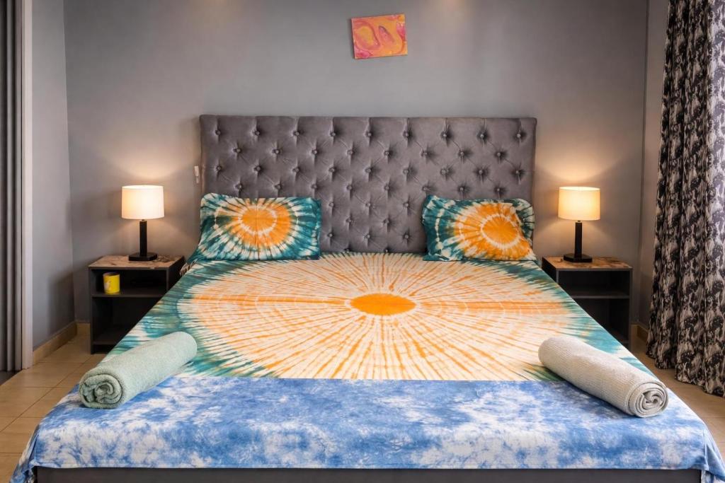 a bedroom with a large bed and two lamps at Cutting Edge Guest House in Daranka