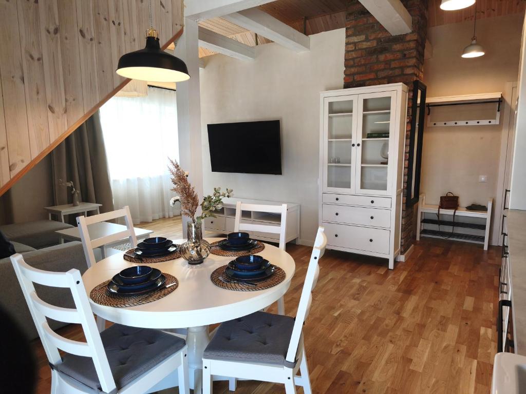 a dining room with a white table and chairs at Loft Apartment Self Check-in in Mažeikiai