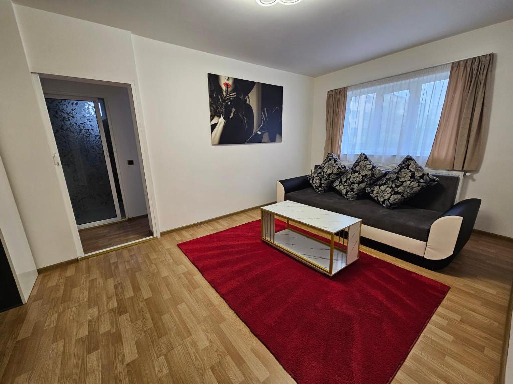 a living room with a black couch and a red rug at Luxury Suites in Alexandria