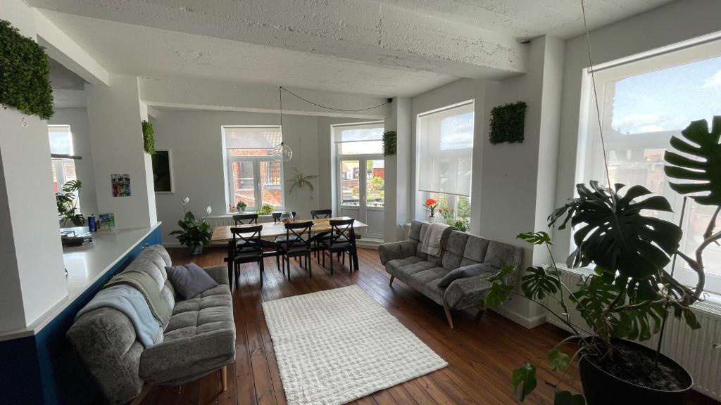 a living room with a couch and a table and chairs at Maro Appartments in Ieper