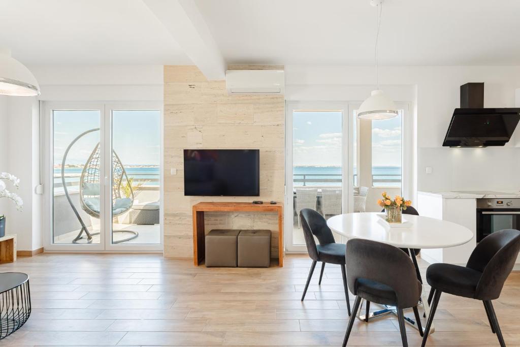 a living room with a table and chairs and a television at Apartments THE BEACH RESORT VIR in Vir