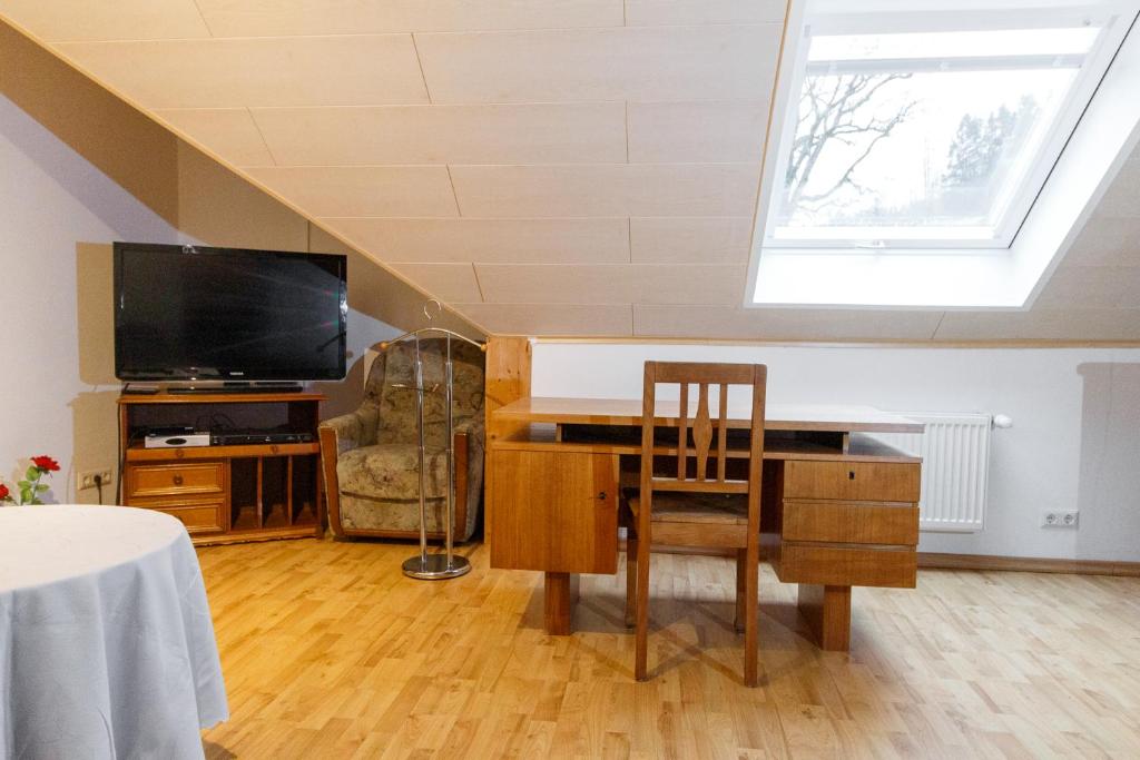 a living room with a desk and a tv at Ferienwohnung Goldhorn in Rödental