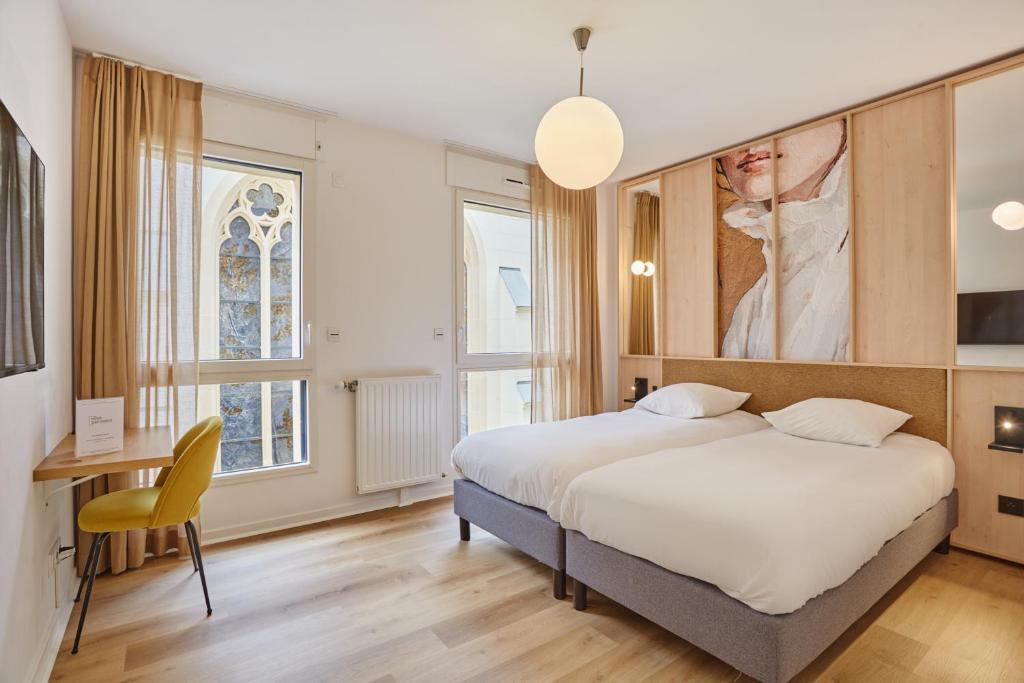 a bedroom with a bed and a desk and windows at MAISON SAINT CHARLES - ASSOCIATION HABITAT et HUMANISME ILE DE FRANCE in Paris