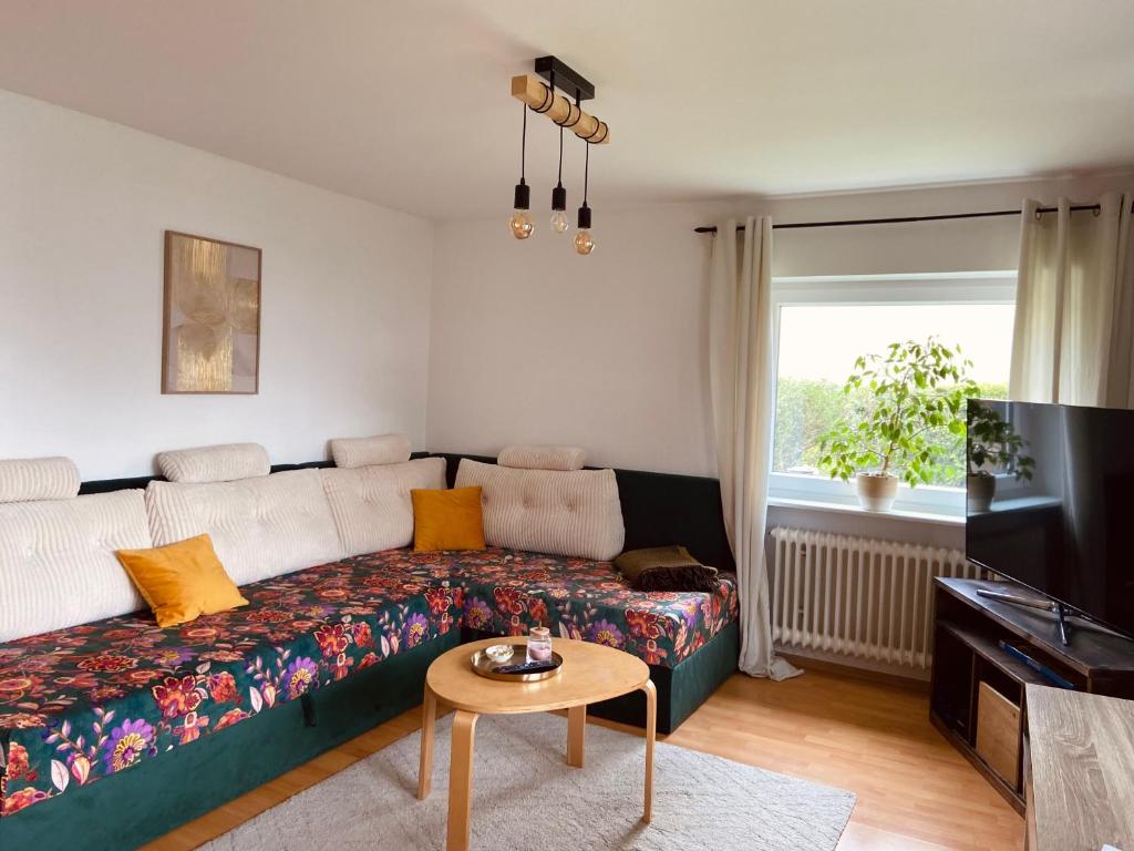 a living room with a couch and a tv at Voll ausgestattete, helle Ferienwohnung auf 80 qm in Wutöschingen