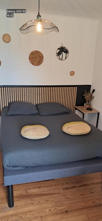 a bed with two pillows and a blue blanket at chambres randonneurs in Plestin-les-Grèves