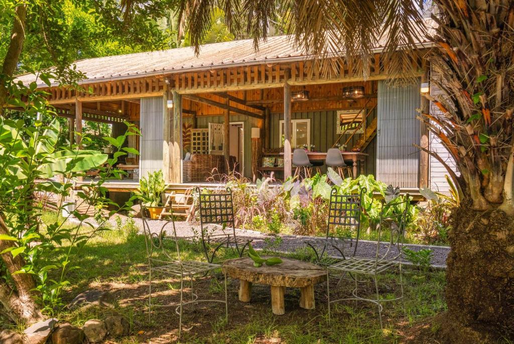 a house with chairs and a bench in the yard at Canopy Lodge - Perfect Mauritius Trip in Tamarin