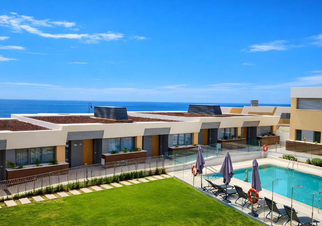 a resort with a swimming pool and the ocean at Eden50 in Mijas Costa